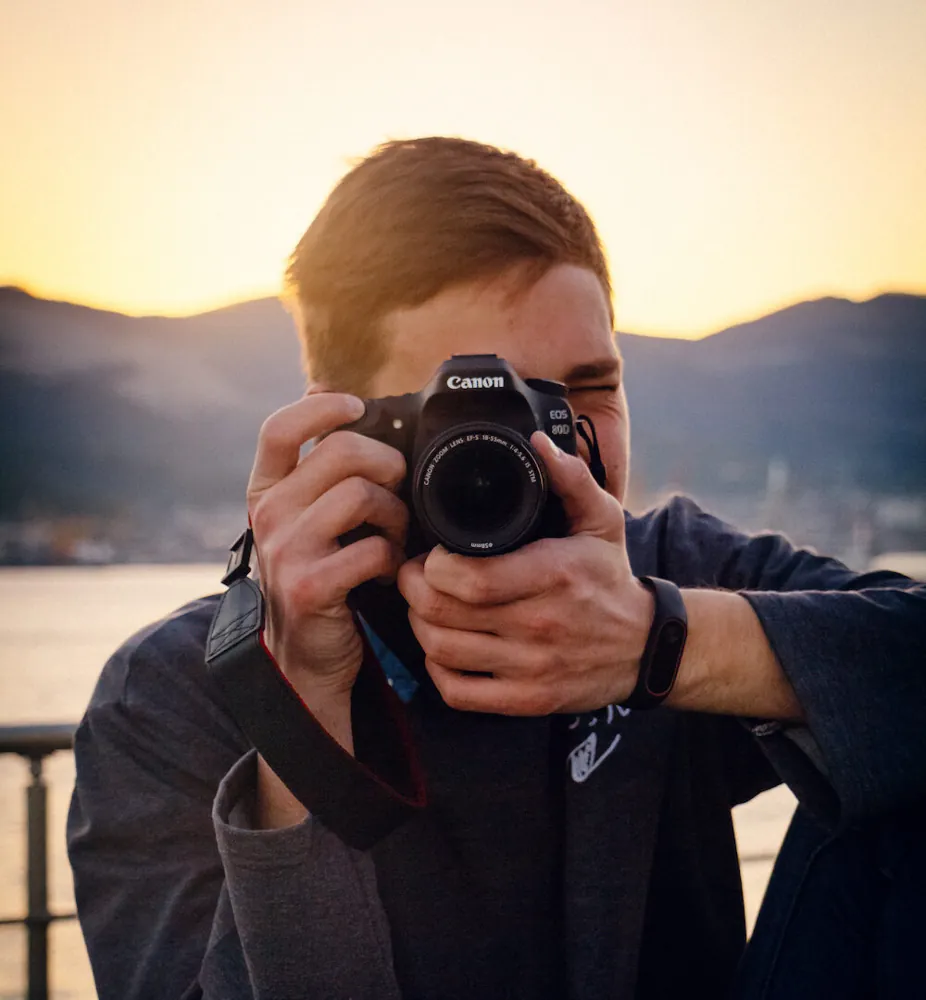 Evgeny taking a photo with a Canon camera at sunset