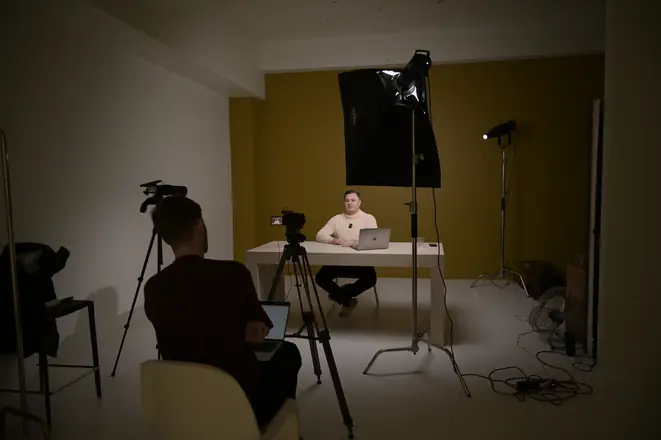 Wide shot of a studio set with a softbox and two cameras