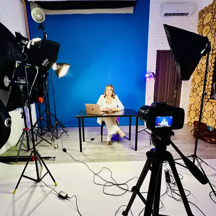Blue studio with lights, camera and an expert on set