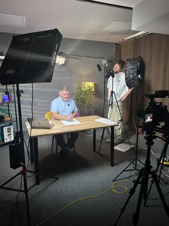Studio set with softboxes and a founder at the desk