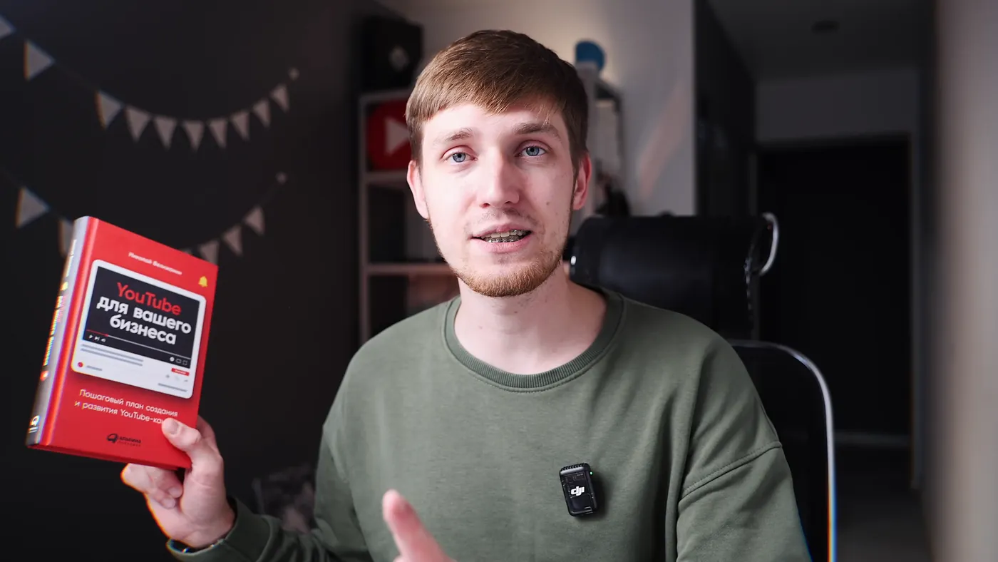 Evgeny Maximov holding the book YouTube for Your Business by Nikolay Vilizhanin