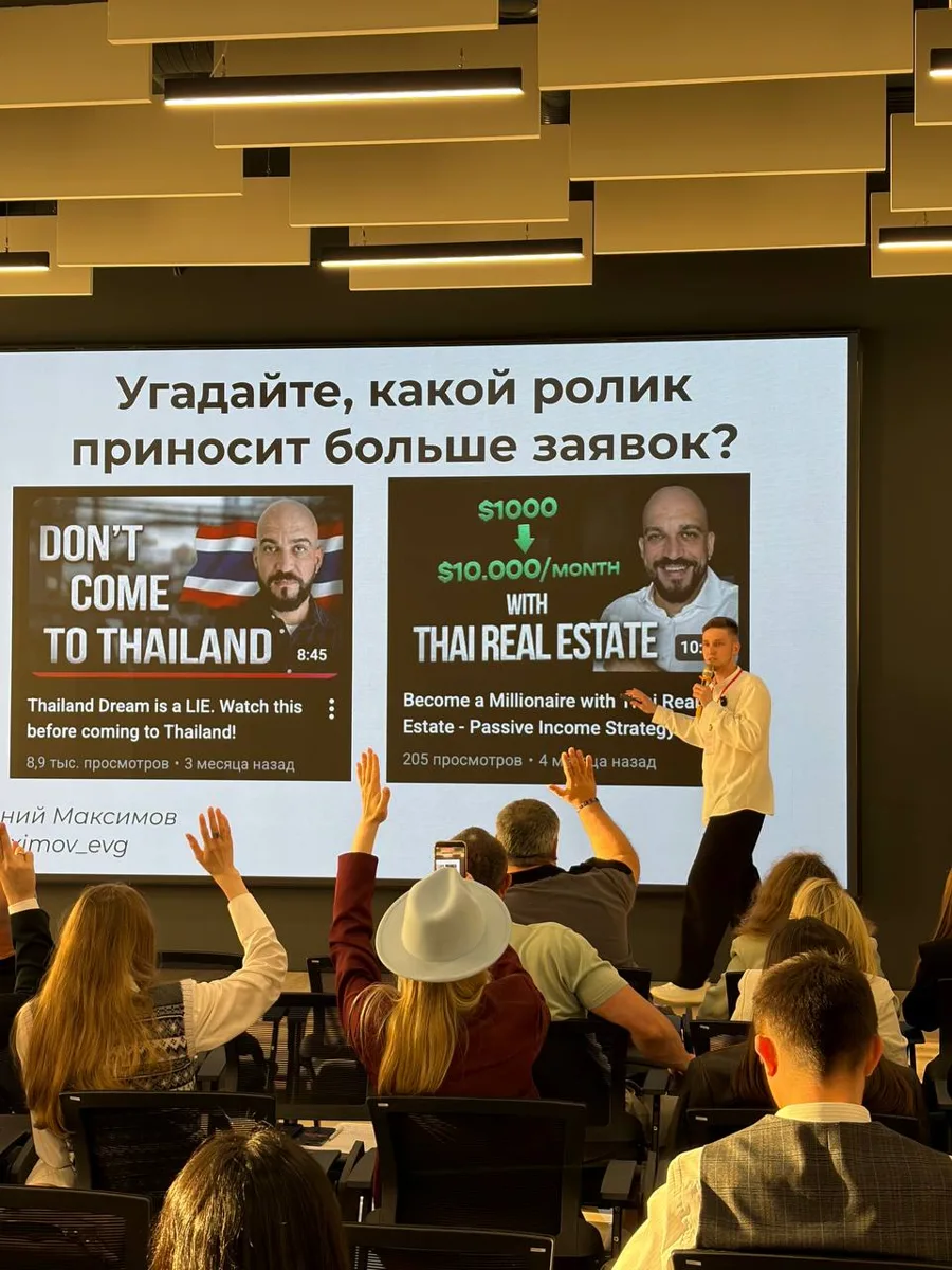Evgeny Maximov on stage asking the audience which of two YouTube videos from a Thai real estate client brings more leads, people raising their hands