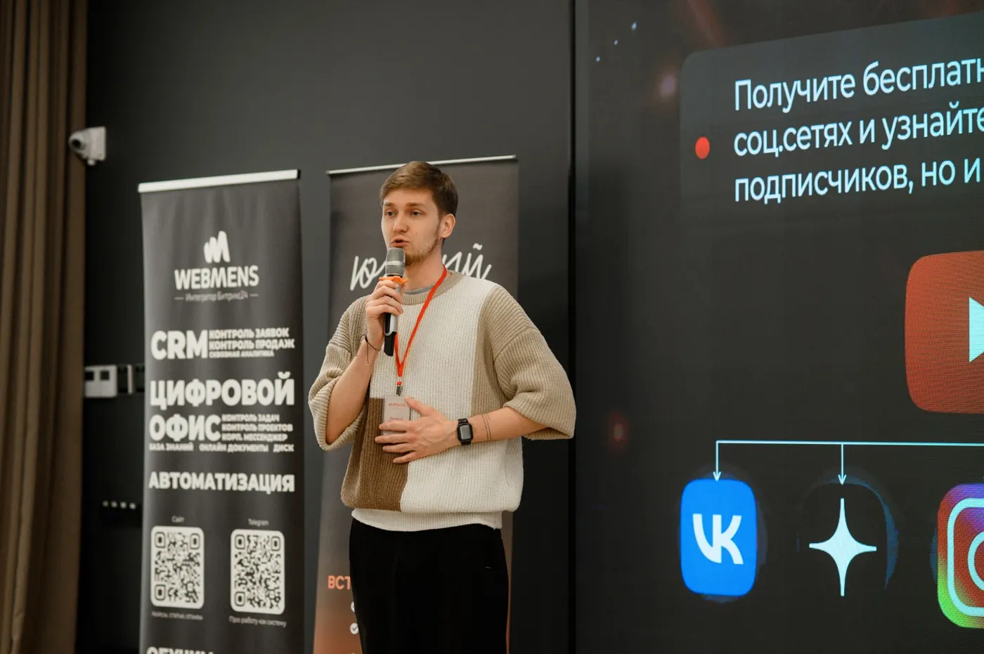 Evgeny Maximov speaking on stage at a marketing club event with a slide about getting clients from social media