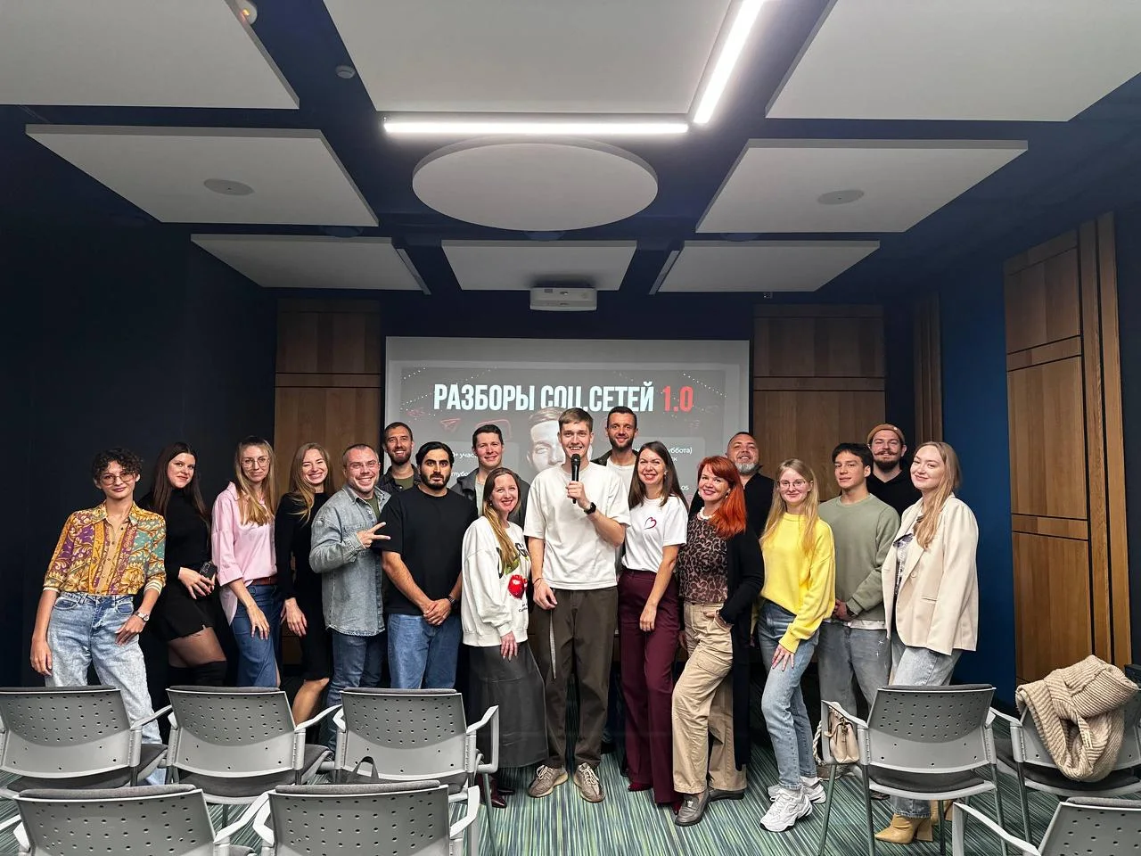 Evgeny Maximov with a microphone and about 20 guests of his own social media breakdown event in a conference room