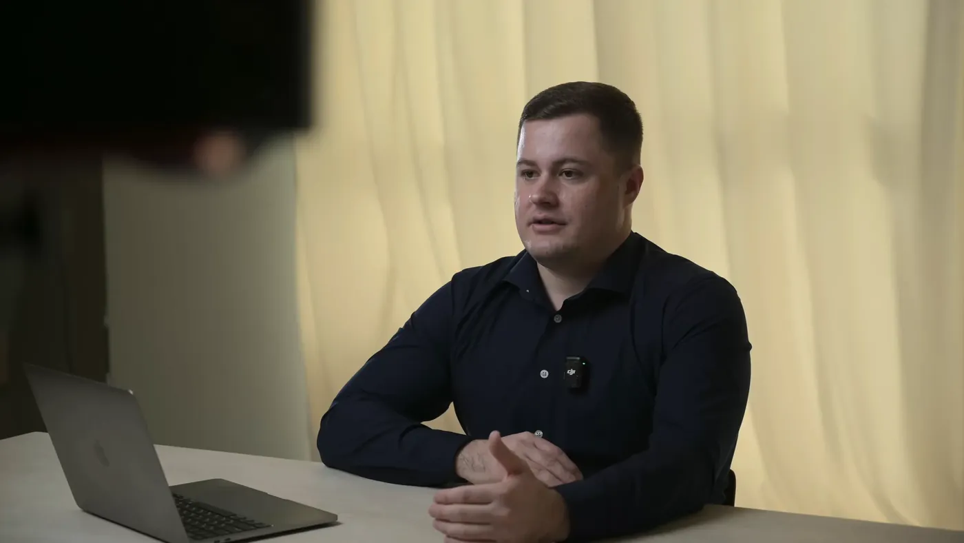 A client being interviewed in a quiet studio with soft light and a laptop on the table