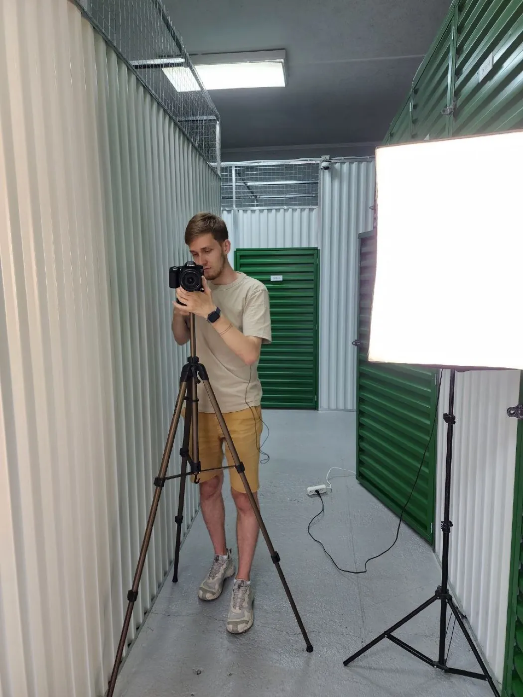Our filmmaker setting up light and camera between storage units