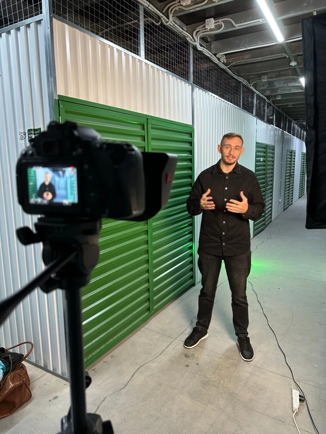 Our shoot at a Tvoy Sklad storage facility: the founder on camera between green storage units